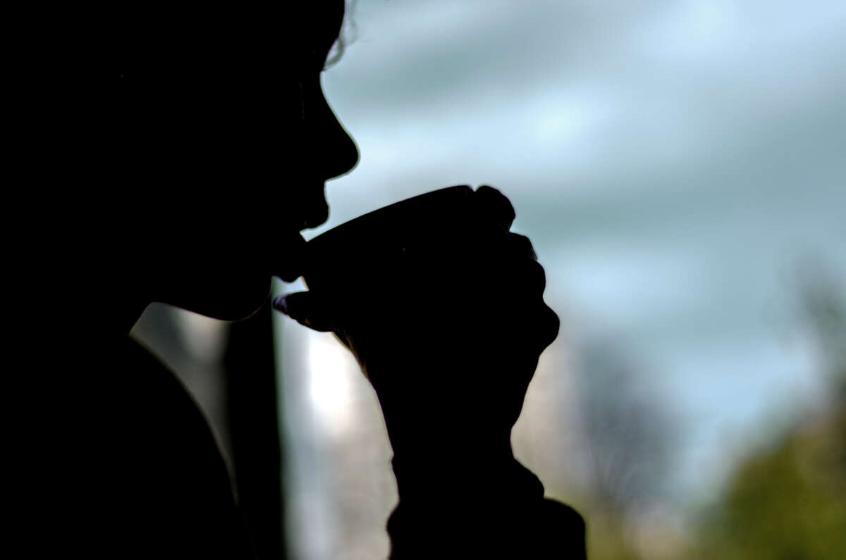 Person drinks from cup in silhouette