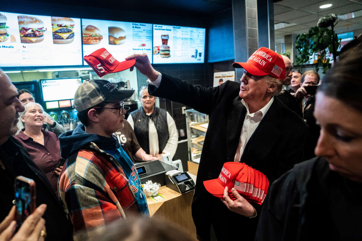 Former President Donald Trump hands out MAGA hats and greets patrons during an off the record stop at a McDonald's restaurant during a visit to East Palestine, Ohio, on February 22, 2023.