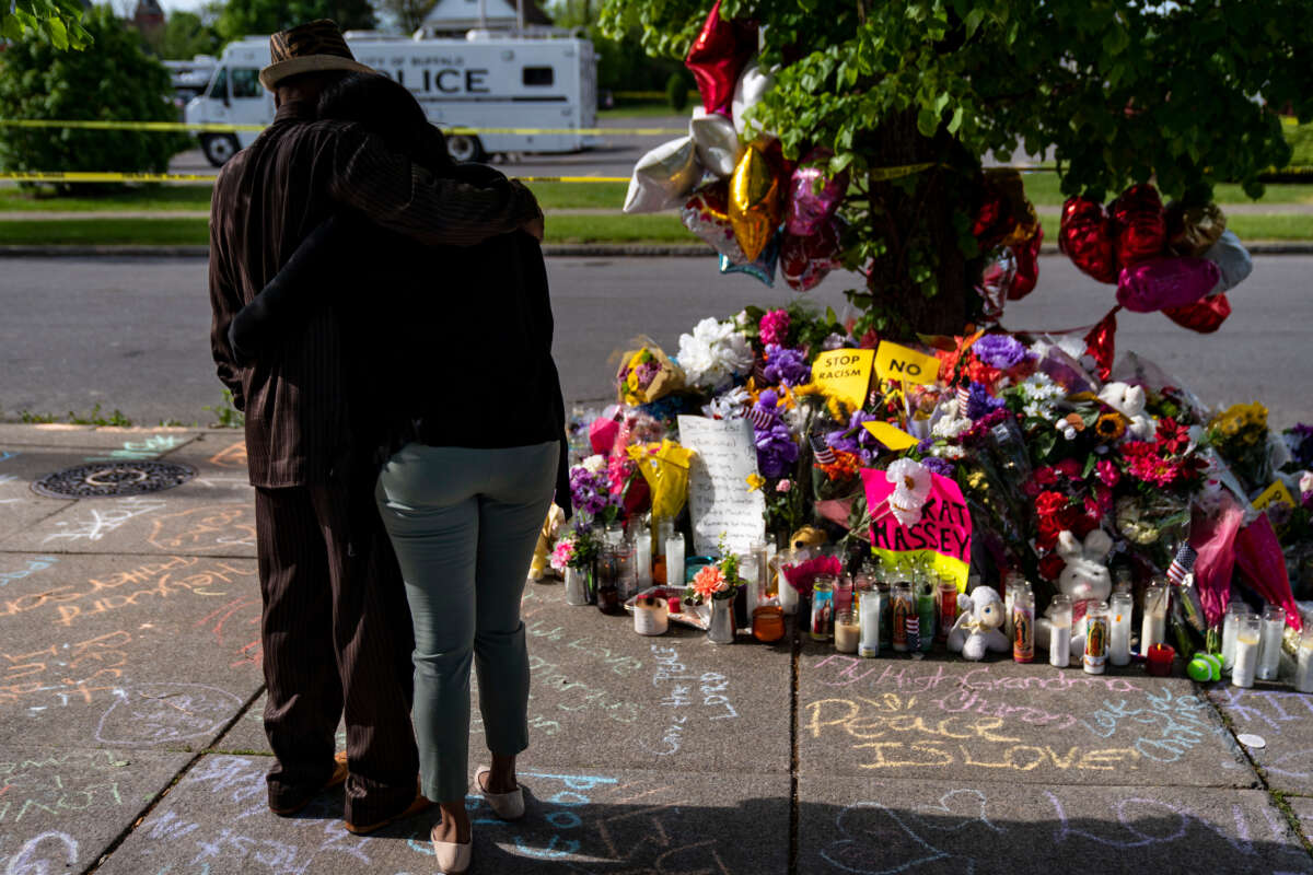 People pay their respects at a makeshift memorial across the street from Tops Friendly Market at Jefferson Avenue and Riley Street on May 18, 2022, in Buffalo, New York.