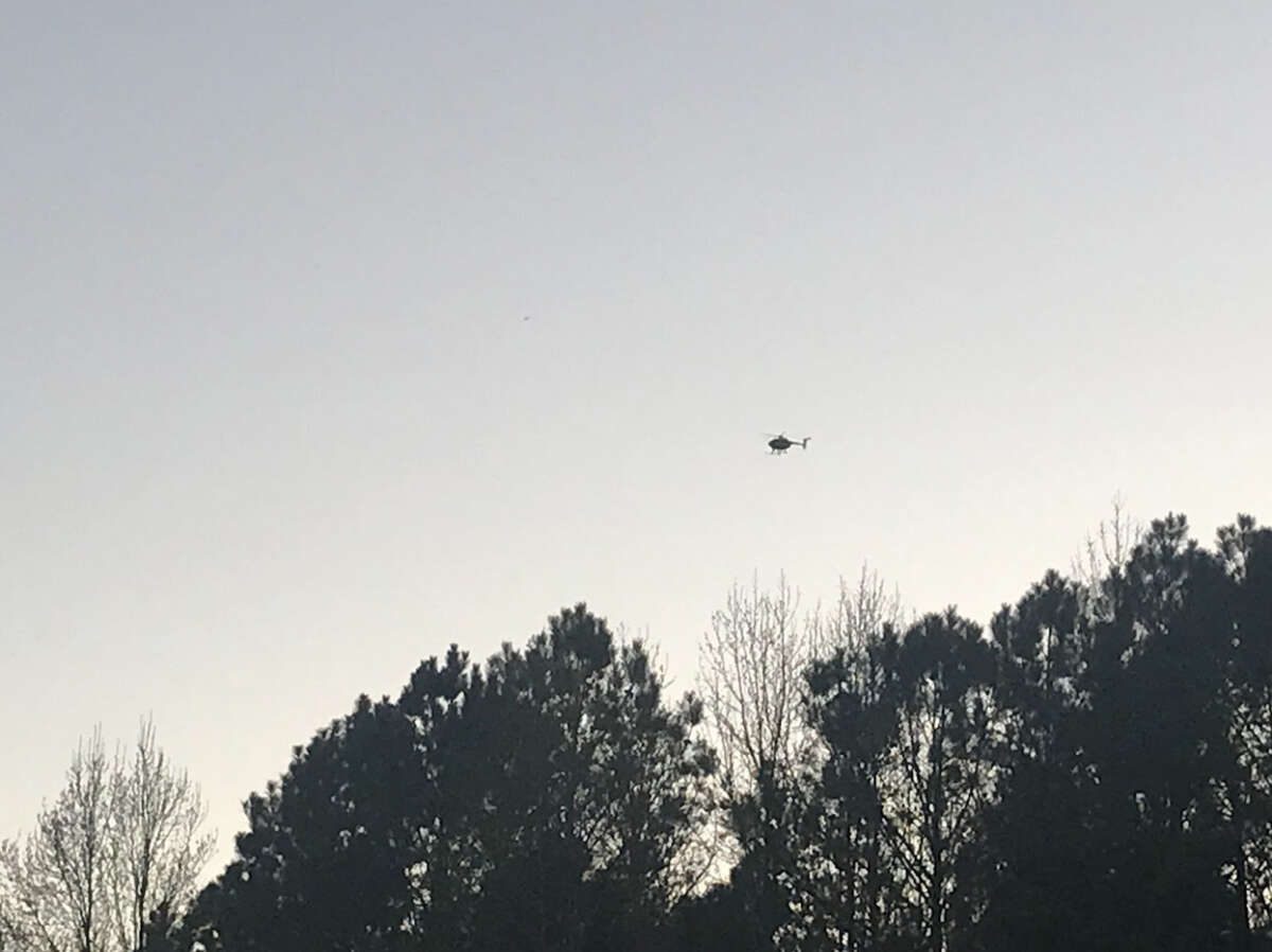 A police helicopter hovering not far from the proposed construction site for the Public Safety Training Center after a vehicle and equipment were ignited.