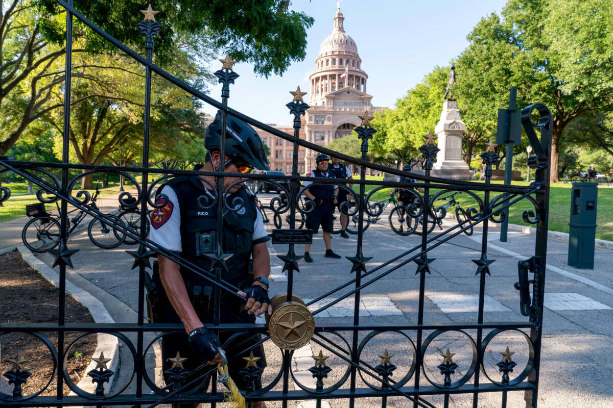 A police officer secures the gate at the State Capitol as abortion rights demonstrators march nearby in Austin, Texas, on June 25, 2022.
