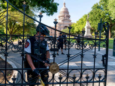 A police officer secures the gate at the State Capitol as abortion rights demonstrators march nearby in Austin, Texas, on June 25, 2022.