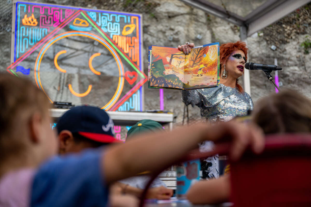 Drag Queen Ona Louise reads a book during a story time reading at the Cheer Up Charlies dive bar on March 11, 2023, in Austin, Texas.