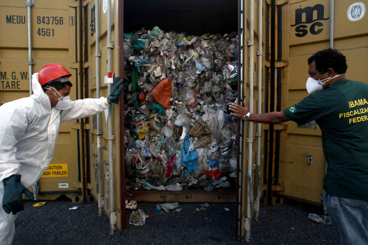 Agents from Brazil's state environmental agency are seen with some of the 1,400 tons of household waste improperly labeled as recyclable plastic exported from Britain, in the port of Santos, Brazil, on July 22, 2009.