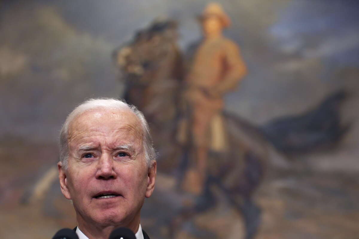 Joe Biden stands bewildered before a painting of Teddy Roosevelt