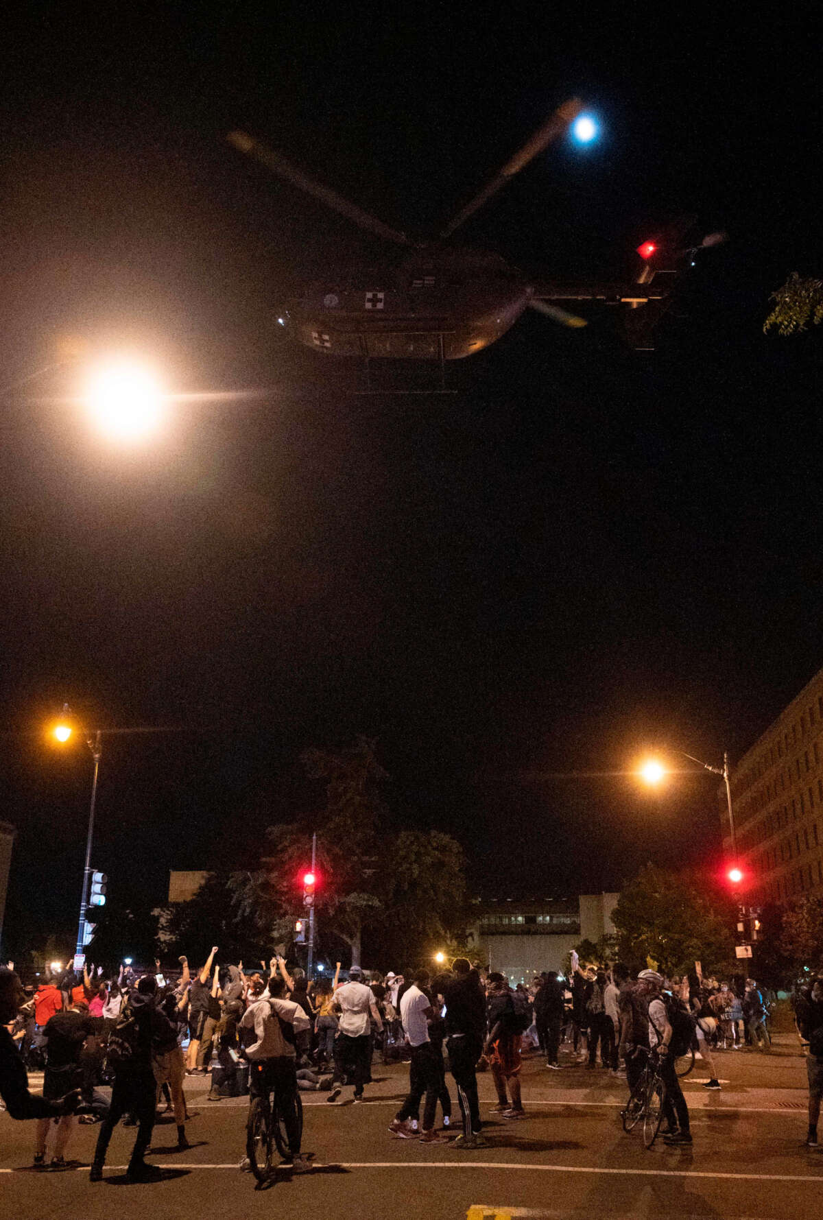 A military helicopter flies low, pushing a strong vertical down wash of air onto the crowd during a protest over the death of George Floyd on June 1, 2020.