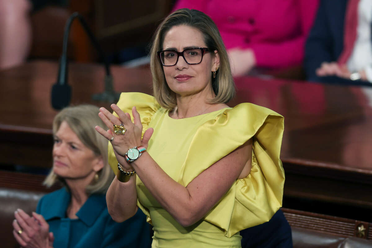 Kyrsten Sinema stands and claps