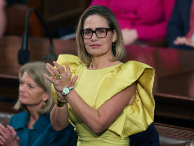 Kyrsten Sinema stands and claps