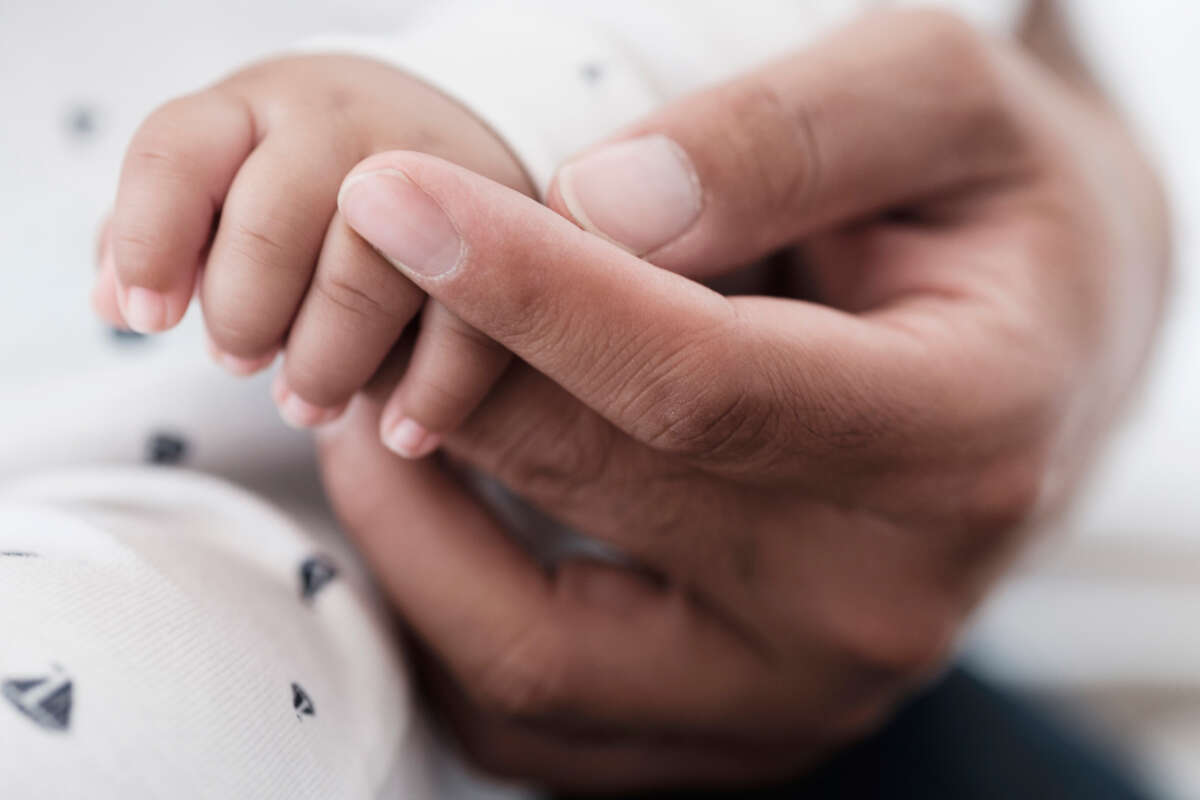 Baby and parent hands together