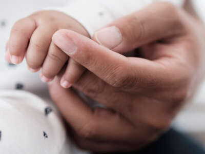 Baby and parent hands together