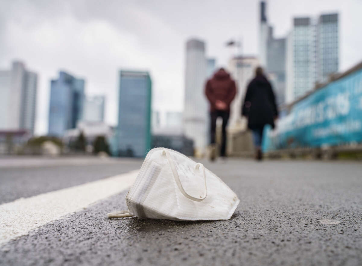 An FFP2 mask is seen lying on a wet pavement in Frankfurt, Germany, on April 18, 2021.