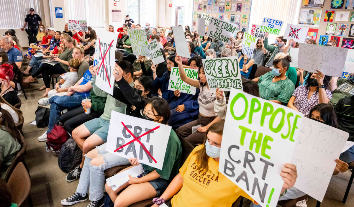 Students against the critical race theory (CRT) ban make their views known while pro-ban speakers talk during the public comment portion of a meeting of the Placentia-Yorba Linda Unified School Board in Placentia, California, on March 23, 2022.