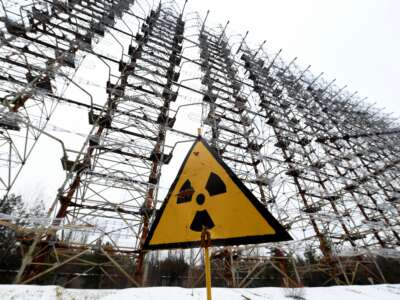 A sign with the radiation warning symbol is seen in front of the construction of the 'Duga' Soviet over-the-horizon radar system near Chernobyl on November 22, 2018.
