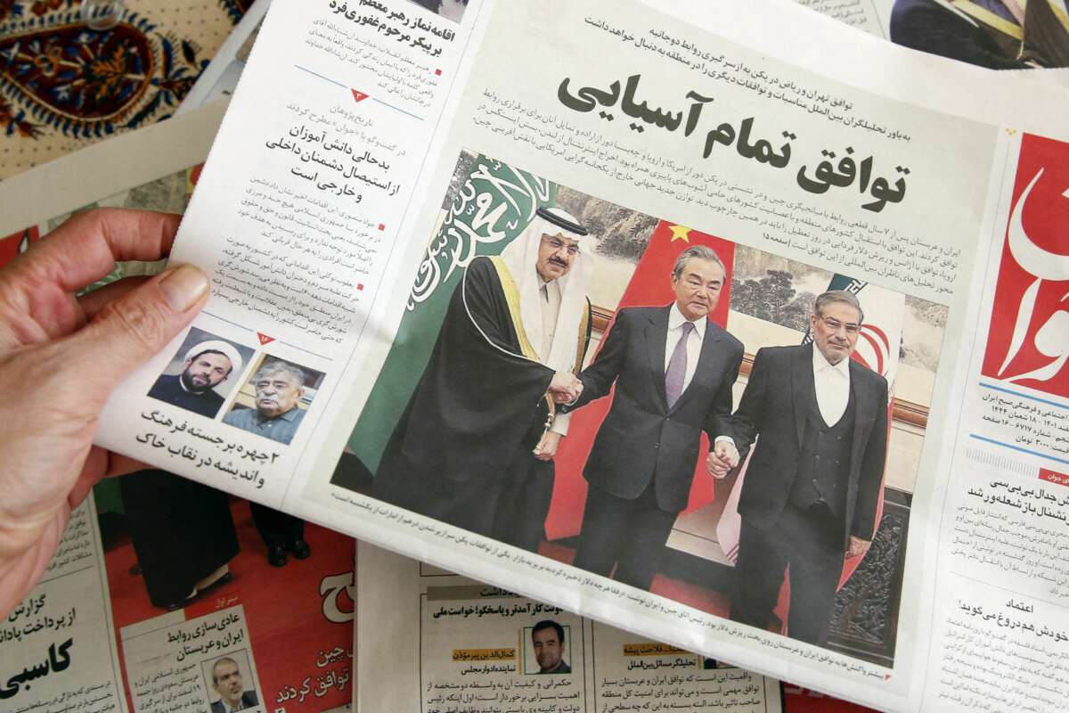 A man in Tehran holds a local newspaper reporting on its front page the China-brokered deal between Iran and Saudi Arabia to restore ties, signed in Beijing the previous day, on March 11, 2023, in Tehran, Iran.