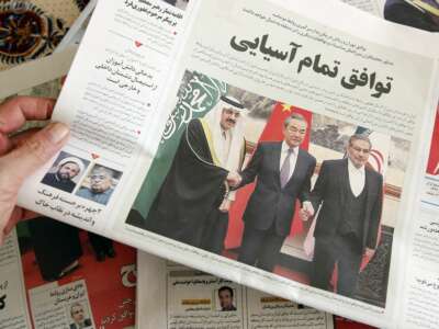 A man in Tehran holds a local newspaper reporting on its front page the China-brokered deal between Iran and Saudi Arabia to restore ties, signed in Beijing the previous day, on March 11, 2023, in Tehran, Iran.