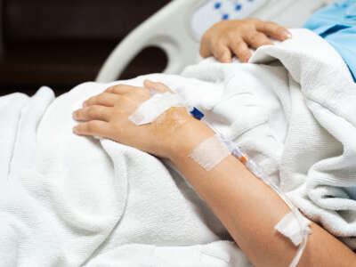 Close up of patient hand receiving IV drip in the hospital bed