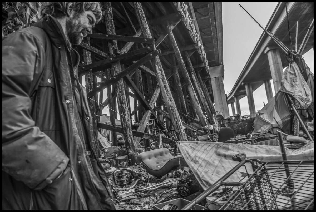 Jason, a resident, looks over the remains of homes and belongings after the big fire.