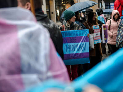 A person holds a sign reading 'Trans Rights are Human Rights' as LGBTQ activists protest on March 17, 2023, in front of the U.S. Consulate in Montreal, Canada.