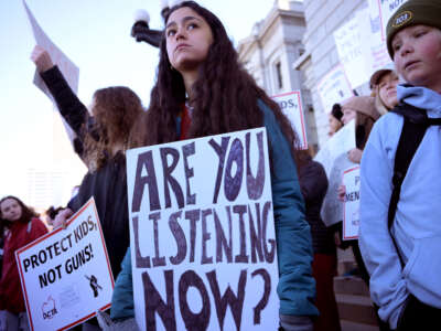 Students participate in the Show Up to End Gun Violence rally at Colorado State Capitol in Denver, Colorado on March 24, 2023. A youth in the middle holds a sign reading 'are you listening now?' while another sign reads 'Protect Kids, Not Guns!'