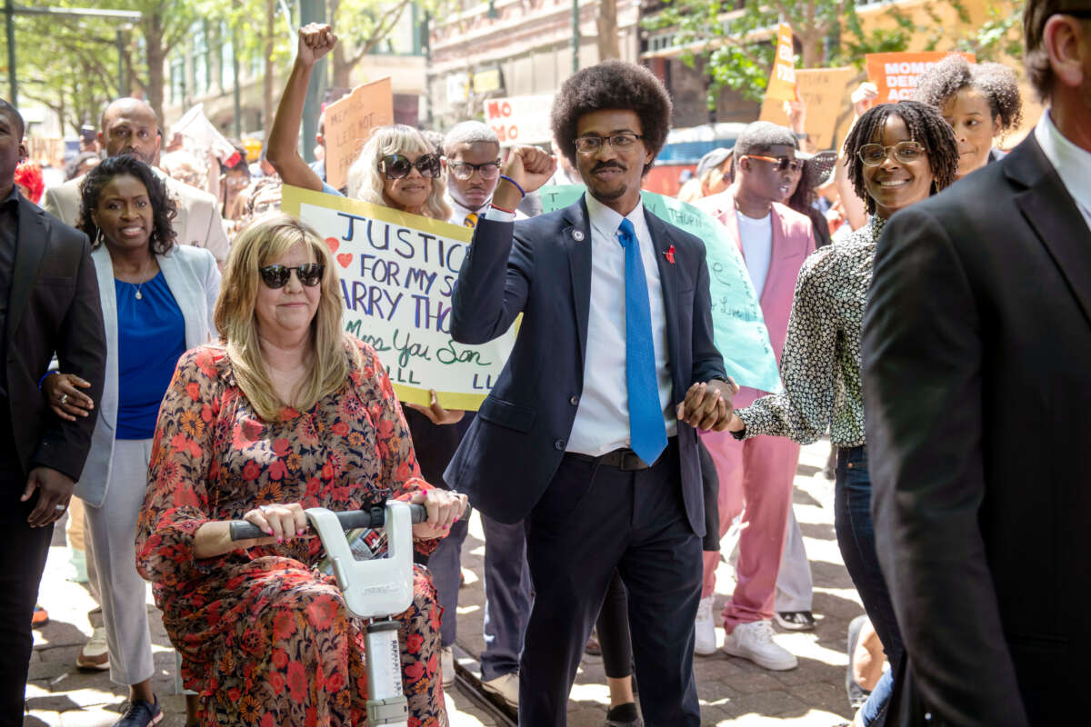 Justin Pearson raises a fist while marching with supporters including Rep. Gloria Johsnon, left, in Memphis, Tennessee, on April 12, 2023, before a vote by the Shelby County Commission to reinstate Pearson after he was expelled from the Tennessee state legislature.