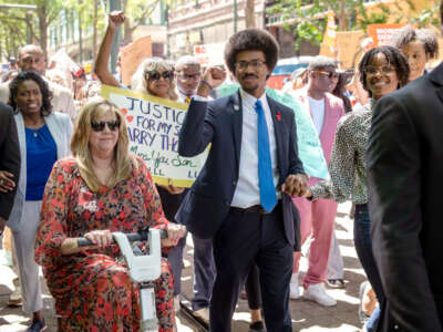 Justin Pearson raises a fist while marching with supporters including Rep. Gloria Johsnon, left, in Memphis, Tennessee, on April 12, 2023, before a vote by the Shelby County Commission to reinstate Pearson after he was expelled from the Tennessee state legislature.