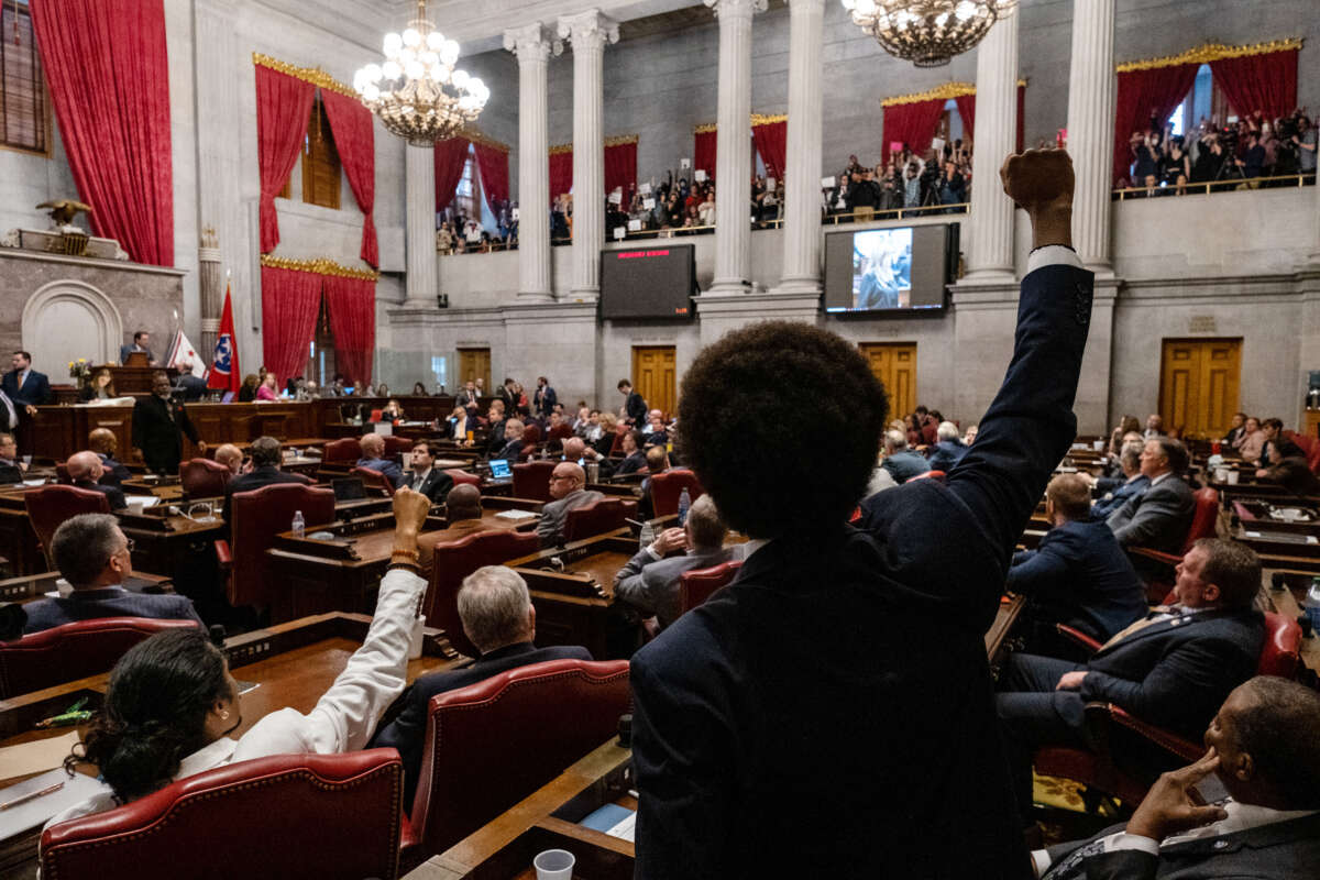 Democratic state Reps. Justin Jones (lower left) of Nashville and Justin Pearson (center) of Memphis gesture to supporters during the vote in which they were expelled from the state Legislature on April 6, 2023, in Nashville, Tennessee.