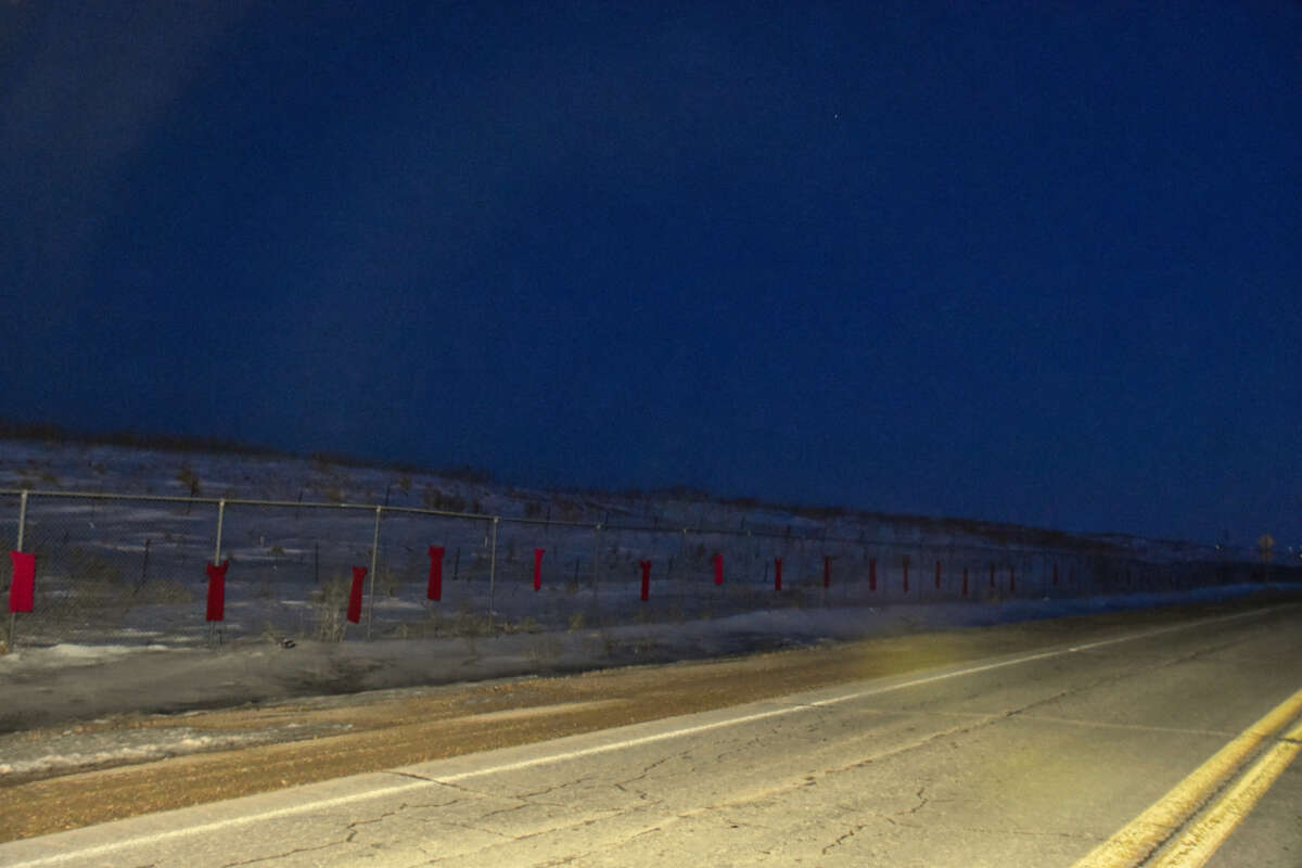 Red dresses commemorate the crisis of Murdered and Missing Indigenous Women, Girls and Two-Spirit people on the fence around Brady Road landfill outside Winnipeg, Manitoba, on March 3, 2023.