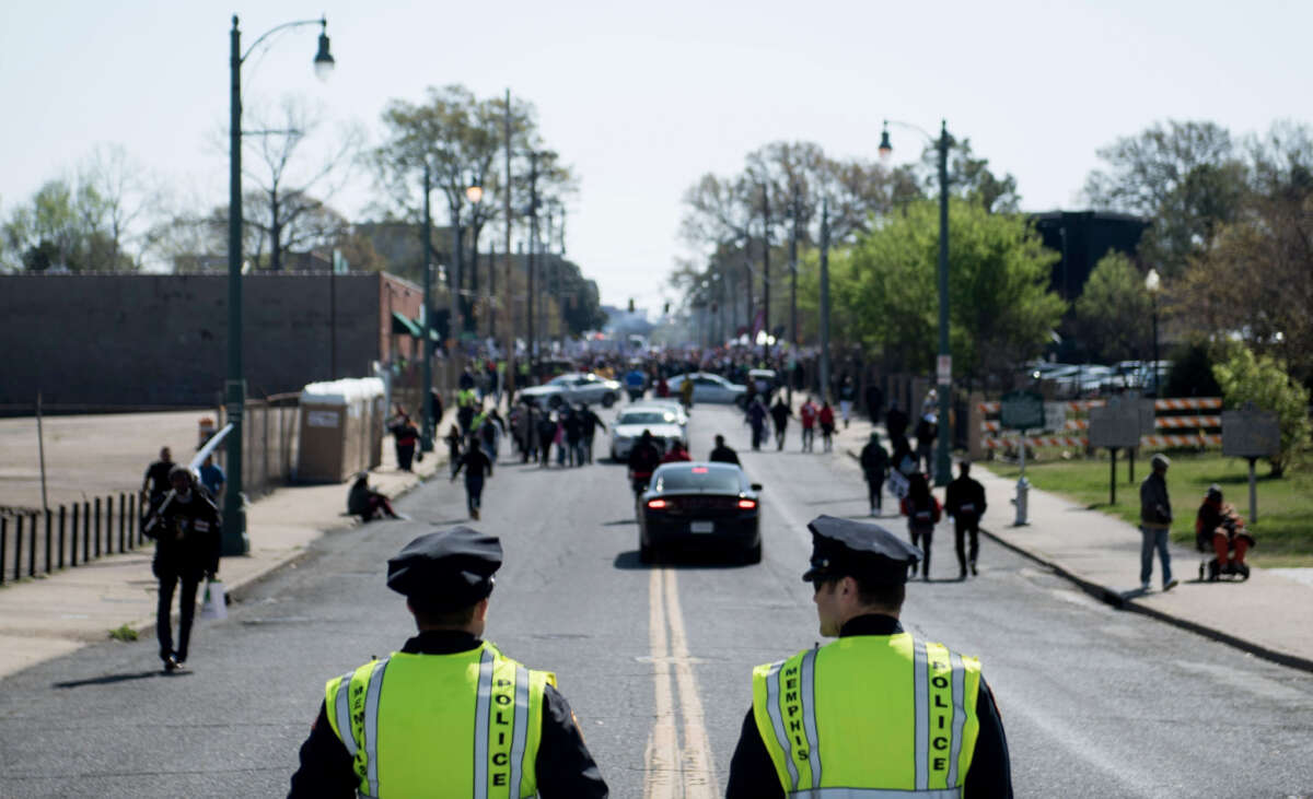 Police watch while people gather for a labor march on the 50th anniversary of the assassination of Martin Luther King Jr. on April 4, 2018, in Memphis, Tennessee.