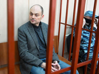 Russian opposition activist Vladimir Kara-Murza sits on a bench inside a defendants' cage during a hearing at the Basmanny court in Moscow on October 10, 2022.