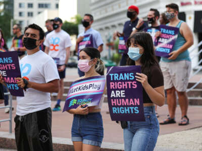 A group of attendees listen to a speaker during the #ProtectTransKids rally outside Orlando City Hall on June 1, 2021, in Orlando, Florida.