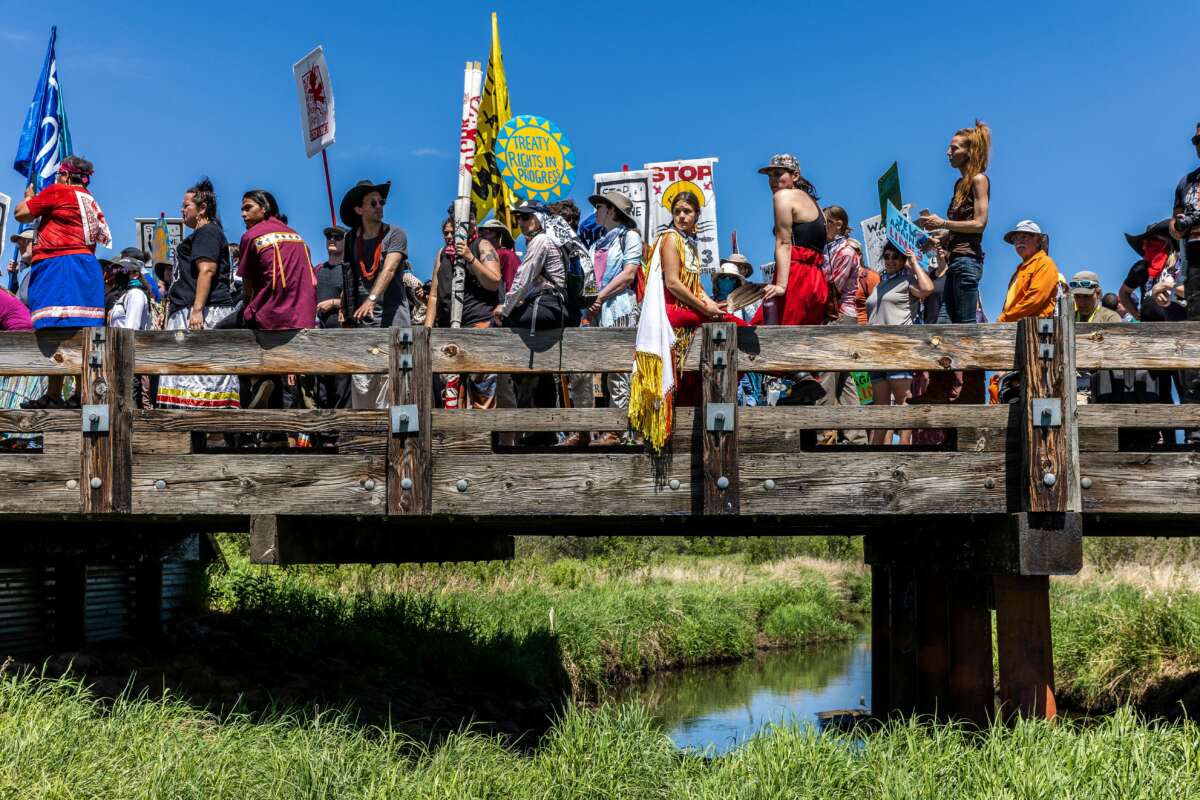 Indigenous climate activists and community members gather on top of a bridge after taking part in a traditional water ceremony during a rally and march to protest the construction of Enbridge Line 3 pipeline in Solvay, Minnesota on June 7, 2021.