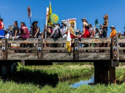 Indigenous climate activists and community members gather on top of a bridge after taking part in a traditional water ceremony during a rally and march to protest the construction of Enbridge Line 3 pipeline in Solvay, Minnesota on June 7, 2021.