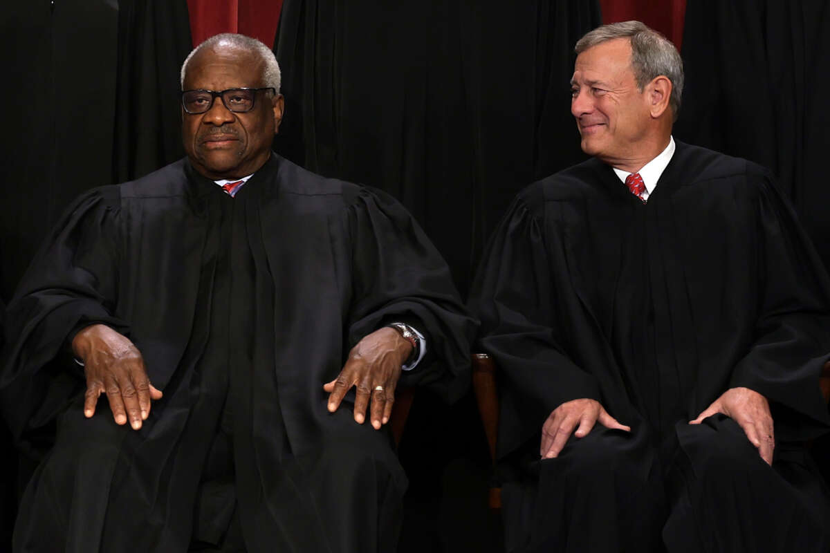United States Supreme Court Associate Justice Clarence Thomas (L) and Chief Justice of the United States John Roberts (R) pose for their official portrait in the Supreme Court building on October 7, 2022 in Washington, D.C.