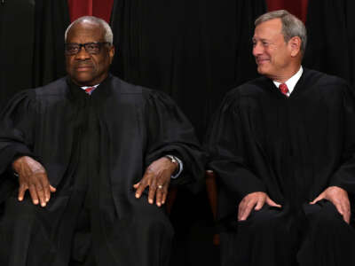 United States Supreme Court Associate Justice Clarence Thomas (L) and Chief Justice of the United States John Roberts (R) pose for their official portrait in the Supreme Court building on October 7, 2022 in Washington, D.C.