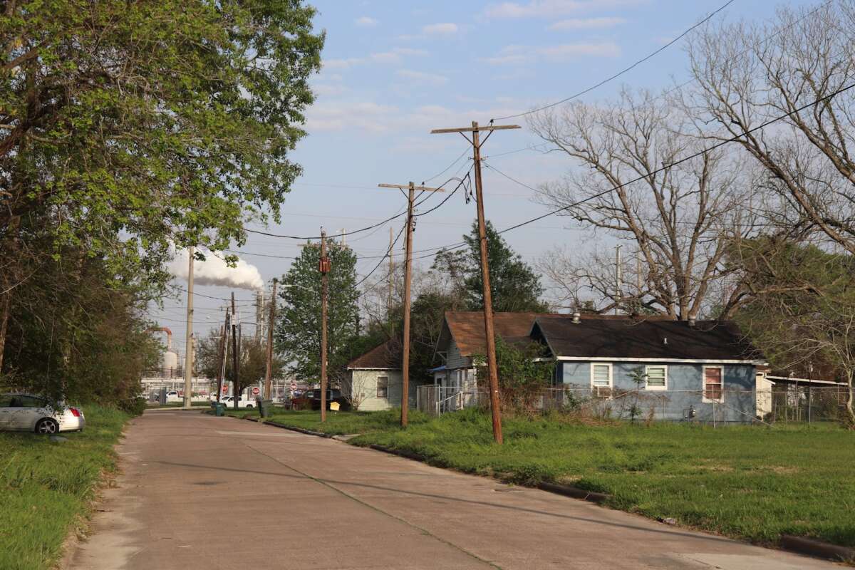 Row of homes in Beaumont, Texas, with smoke in the distance