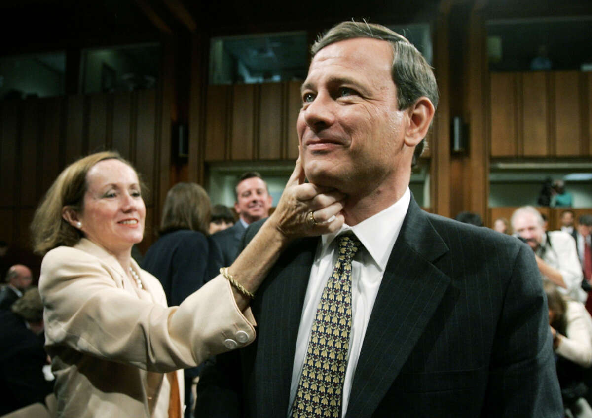 Jane Sullivan Roberts (L), wife of Supreme Court Chief Justice Nominee John Roberts (R), wipes lipstick from Roberts's cheek after giving him a kiss at the end of the judge's testimony during confirmation hearings before the Senate Judiciary Committee September 15, 2005 in Washington, D.C.