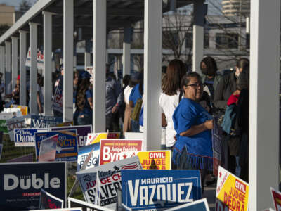 Voters wait in line outside of a polling place in Houston, Texas on March 1, 2022.