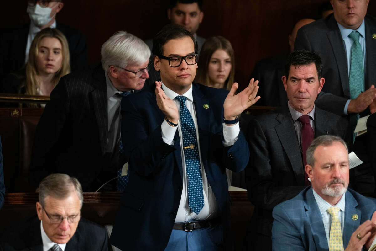 Rep. George Santos stands to clap during a hearing
