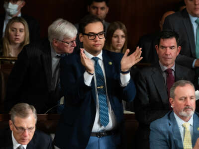 Rep. George Santos stands to clap during a hearing