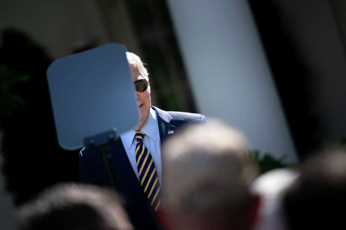 Joe Biden's face peers from behind a teleprompter