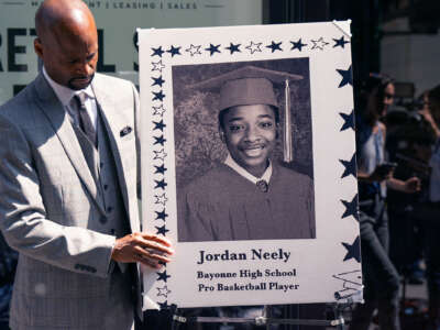 Andre Zachary, father of deceased Jordan Neely, adjusts a memorial portrait for a press conference in the wake of the arrest of Daniel Penny in New York City, on May 12, 2023.