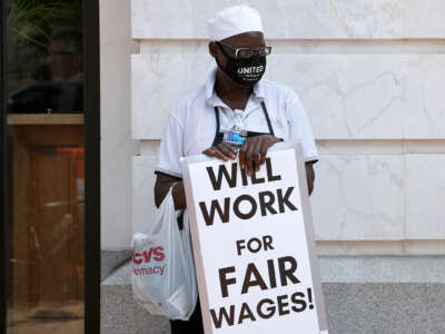 A restaurant worker participates in a "Wage Strike" demonstration, organized by One Fair Wage, outside of the Old Ebbitt Grill restaurant on May 26, 2021, in Washington, D.C.