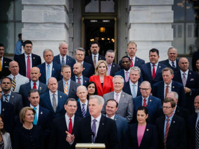 House and Senate republicans stand behind Kevin Mccarthy as he speaks into a microphone