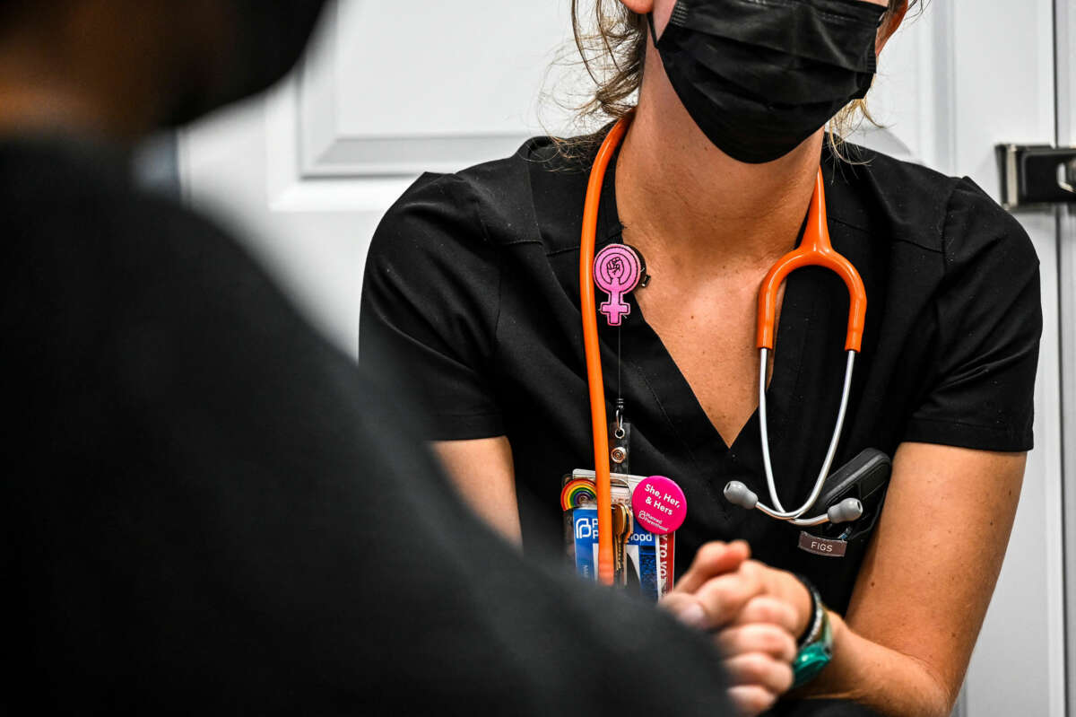 A clinic worker speaks with a patient