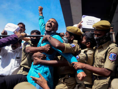 A man yells while being arrested by several police officers