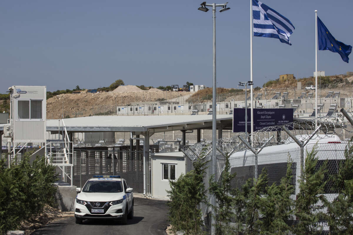 A police car drives past the main gate of the newly established refugee camp on the island of Samos, Greece, on September 18, 2021.