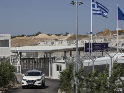 A police car drives past the main gate of the newly established refugee camp on the island of Samos, Greece, on September 18, 2021.