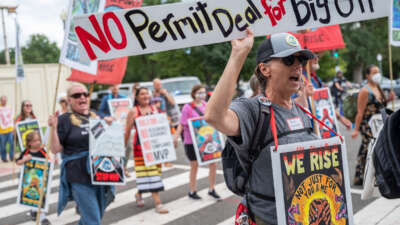 Demonstrators with Appalachian and Indigenous climate advocates march against the Mountain Valley Pipeline project approved as part of the Inflation Reduction Act in Washington, D.C., on September 8, 2022, with signs that read "No Permit Deal for Big Oil"