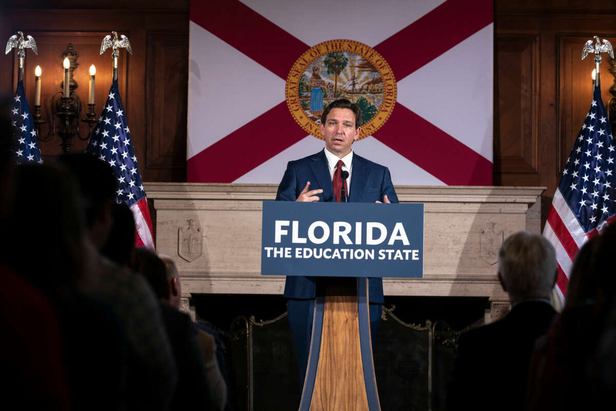 Ron Desantis speaks behind a podium with a sign reading "FLORIDA: THE EDUCATION STATE"