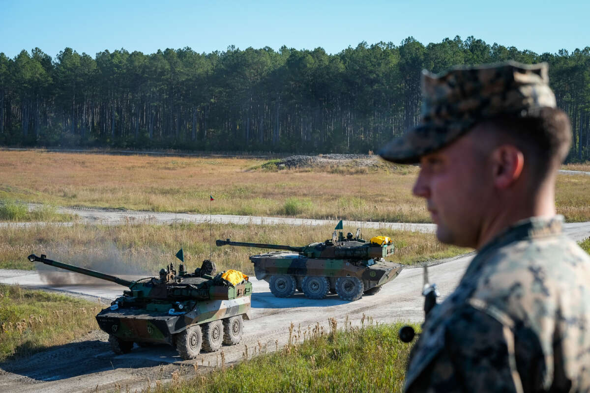 A soldier with two driving tanks behind at Camp Lejeune in Jacksonville, North Carolina, on October 27, 2017.